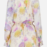 The Luna Ruffle Floral Playsuit by ZIMMERMANN is a sheer, long-sleeved pastel piece with romantic yellow, purple, and pink florals, a cinched waist, and ruffled hems on the sleeves and shorts.