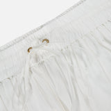 Close-up of the Mahon Embroidered Midi Skirt by ZIMMERMANN, featuring an elastic waistband with a drawstring through metal eyelets. The ivory fabric is soft and lightweight—ideal for summer wear.