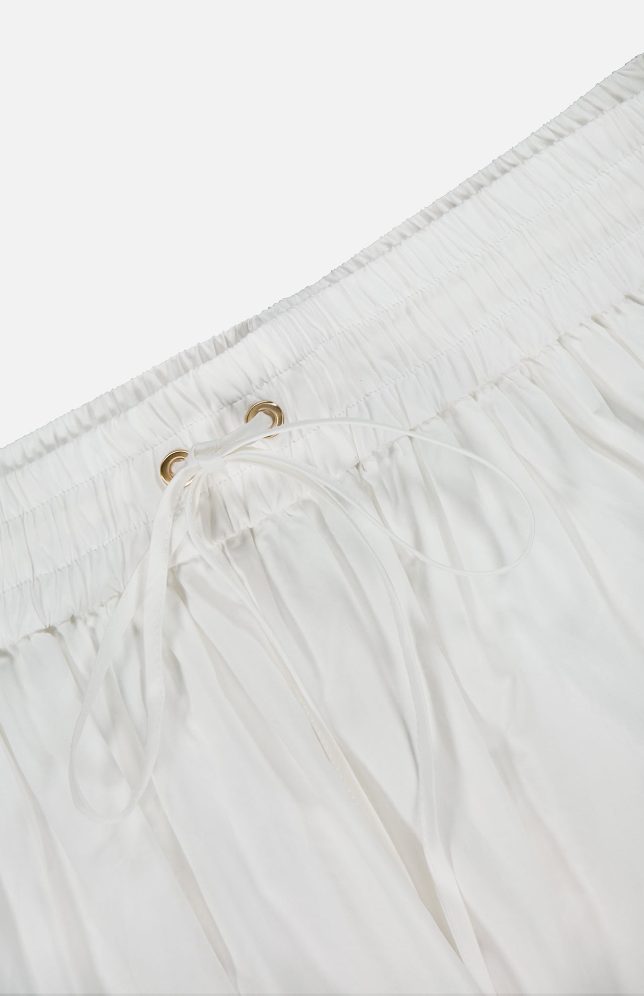 Close-up of the Mahon Embroidered Midi Skirt by ZIMMERMANN, featuring an elastic waistband with a drawstring through metal eyelets. The ivory fabric is soft and lightweight—ideal for summer wear.
