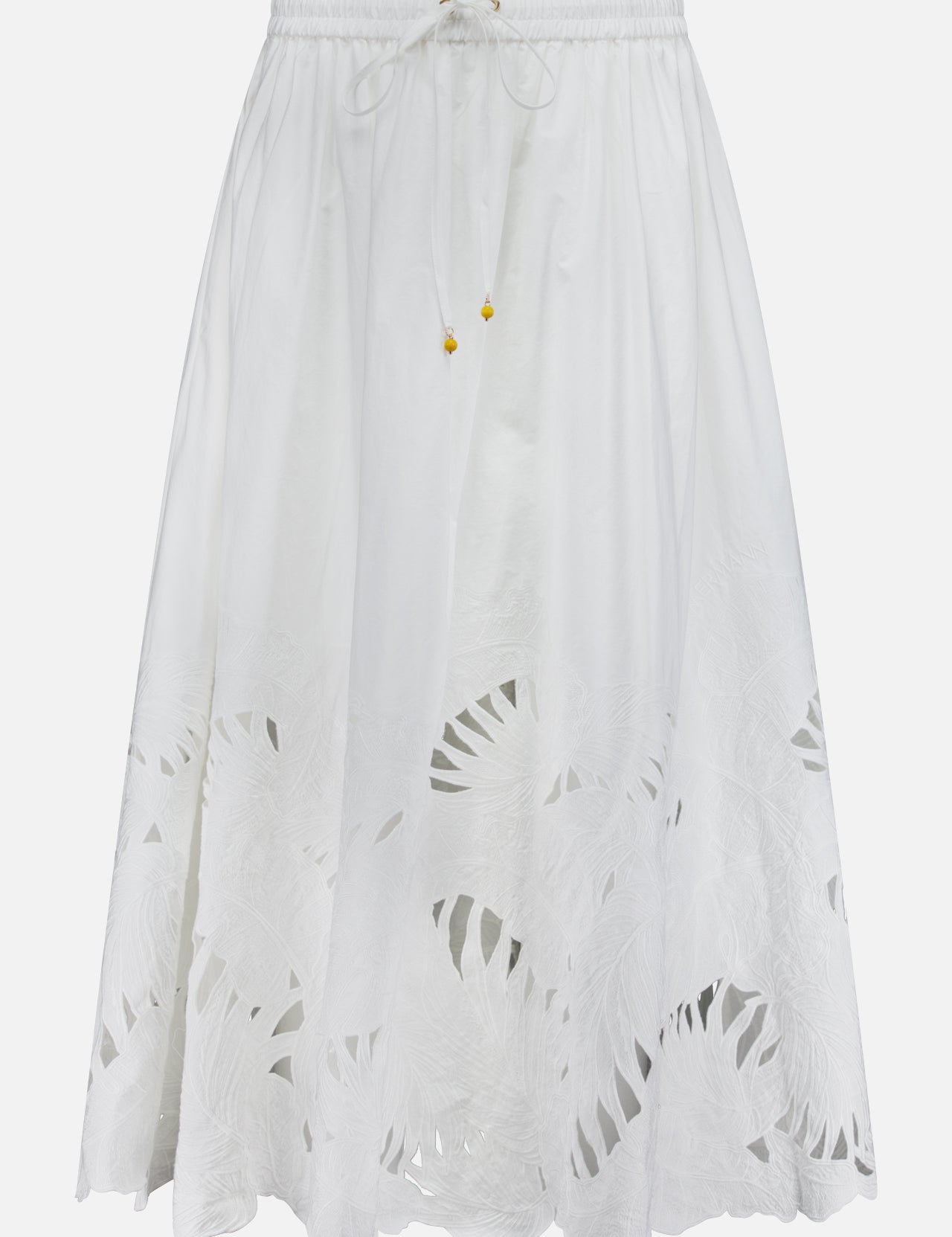 The ZIMMERMANN Mahon Embroidered Midi Skirt features an elastic waistband, drawstring ties, and a leafy cut-out hem. This ivory cotton skirt is lightweight, slightly sheer, and ideal for summer.