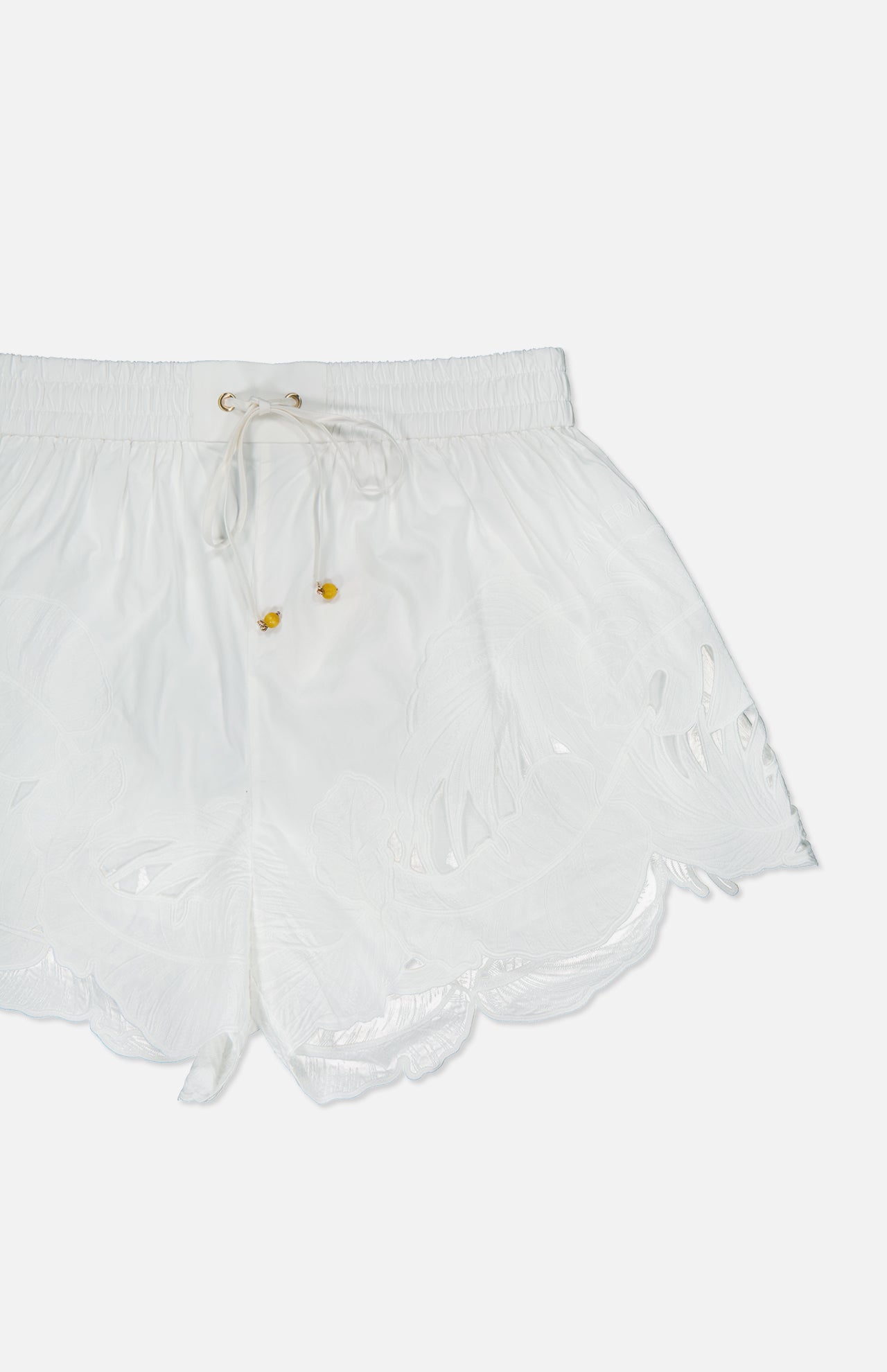 The ZIMMERMANN Mahon Embroidered Drawstring Short features an ivory high-rise design, scalloped hem, elastic waistband with gold-accented drawstring, and delicate leaf embroidery on cotton.