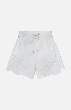 The ZIMMERMANN Mahon Embroidered Drawstring Short features an ivory hue, gold bead accents, and leaf-patterned cutouts along the scalloped hem. Made from cotton, these high-rise shorts are shown against a plain white background.