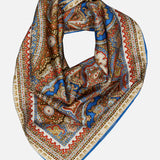 Zimmermann Printed Silk Square 70 Scarf featuring a blue, red, and tan paisley print with a repeating brand name along the border.