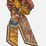 A Zimmermann Printed Silk Tie Scrunchie featuring long, ribbon-like tails in a colorful, spiced paisley print.