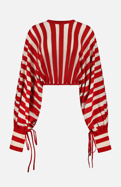 The ZIMMERMANN Rebellion Drawn Cuff Sweater features a cropped fit, long blouson sleeves, red and cream vertical and diagonal stripes, and cinched cuffs and hem with adjustable drawstrings for a bold look.