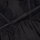 Close-up of the ZIMMERMANN Valiant Lace Trim Midi Dress in black, highlighting its lace details, sheer fabric, and a satin ribbon accent running horizontally across the bodice.