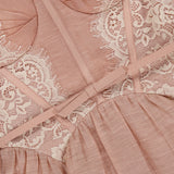 Close-up of the Valiant Lace Trim Mini Dress by ZIMMERMANN, featuring blush pink fabric with cream lace trim and intricate stitching that highlights the delicate texture and elegant design of this romantic piece.