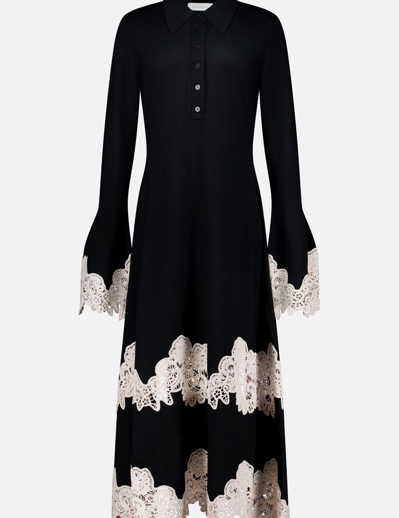 The Valiant Merino Lace Dress by ZIMMERMANN is a black merino wool midi dress featuring a collared neckline, buttoned front, and a graceful flared skirt, elegantly finished with beige lace-embroidered trim on the cuffs, hem, and near the lower skirt.