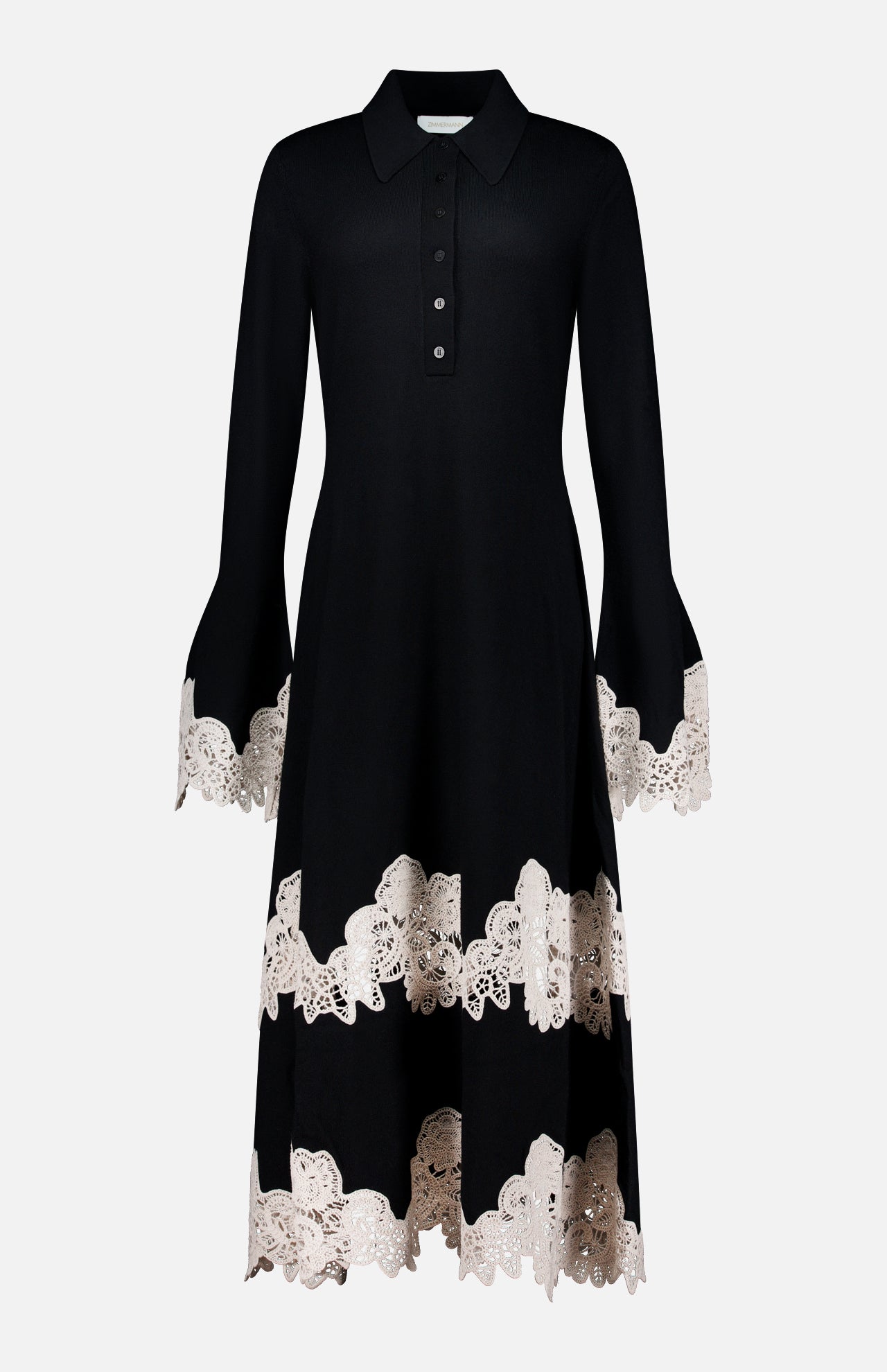 The Valiant Merino Lace Dress by ZIMMERMANN is a black merino wool midi dress featuring a collared neckline, buttoned front, and a graceful flared skirt, elegantly finished with beige lace-embroidered trim on the cuffs, hem, and near the lower skirt.