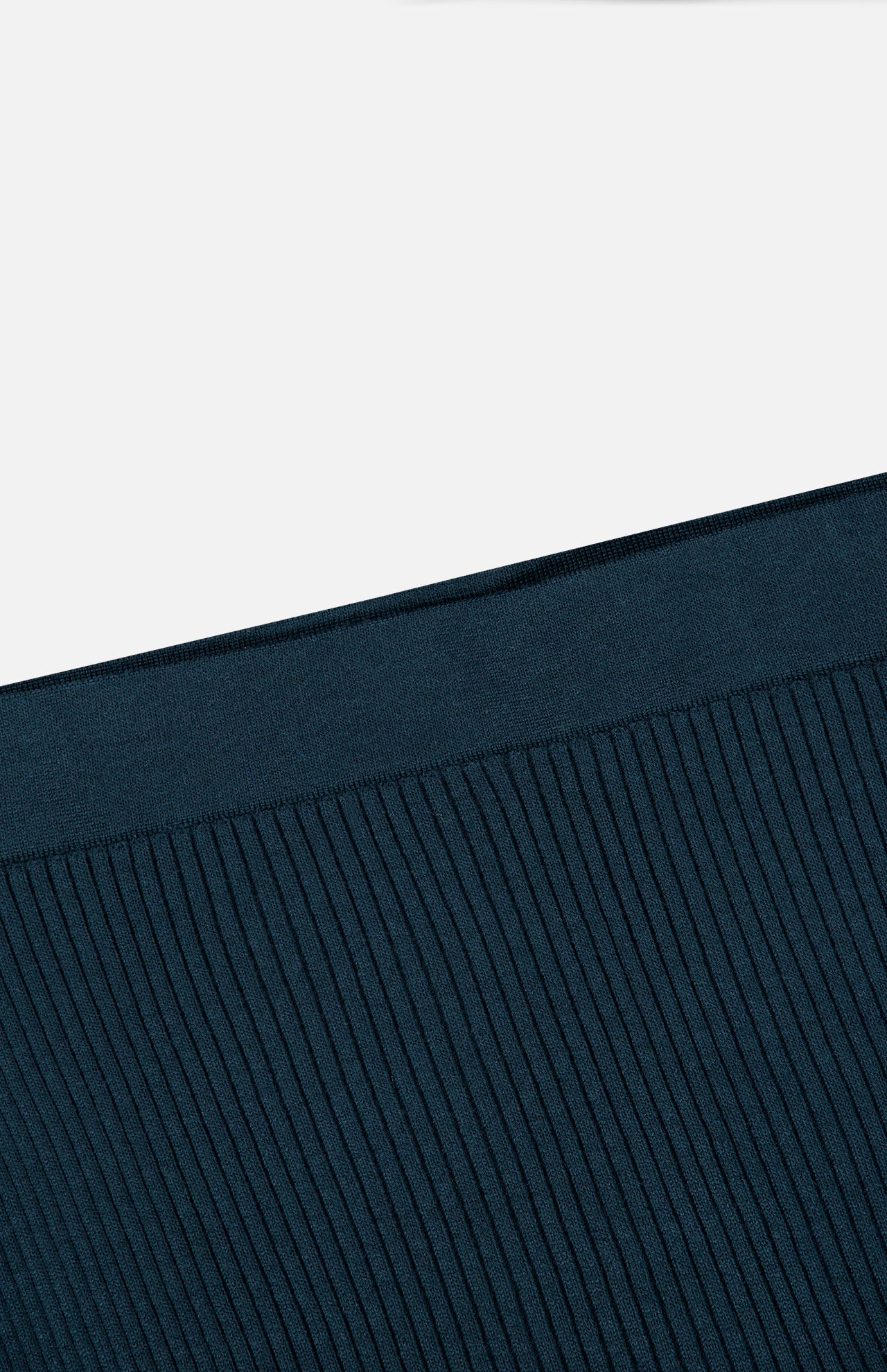 Close-up of the ribbed, dark teal waistband of the ZIMMERMANN Valiant Merino Straight Midi Skirt, shown against a plain white background. The vertical texture is evenly spaced.
