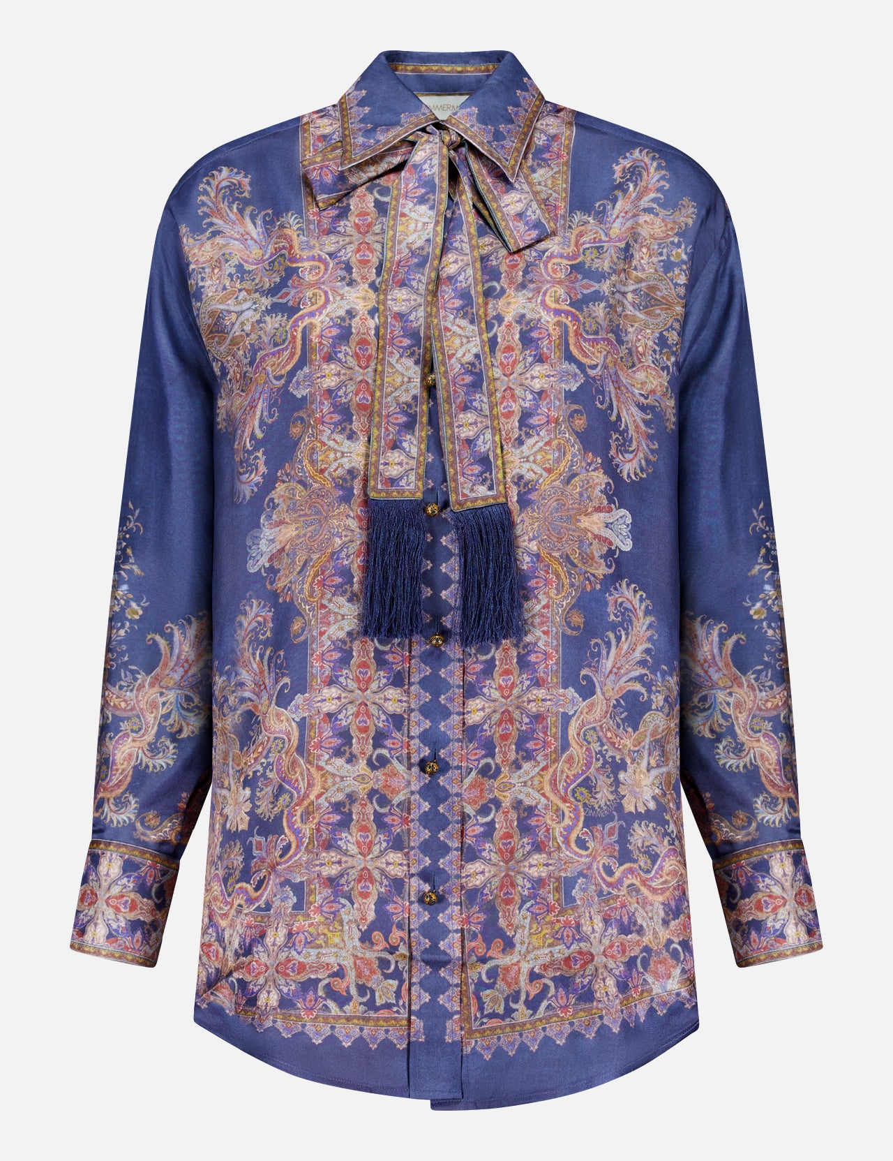 The ZIMMERMANN Valiant Relaxed Bow Collar Shirt is a long-sleeve, button-up silk blouse in deep blue, featuring an ornate gold and pink paisley pattern and a matching bow collar necktie embellished with fringed tassels—offering the perfect blend of designer women’s shirt elegance and subtle bohemian charm.