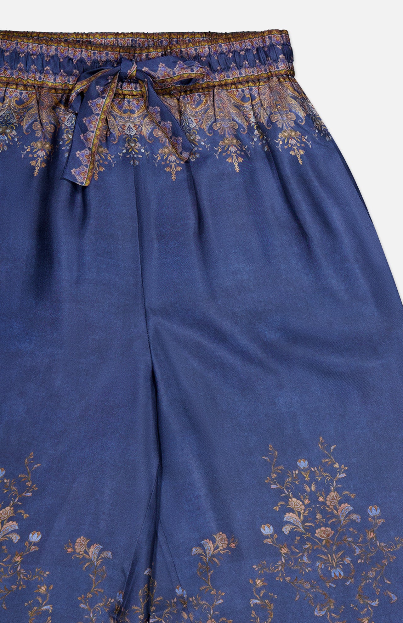 The Valiant Paisley Print Track Pant by ZIMMERMANN features a high-rise, pull-on silhouette with a drawstring waistband, adorned with delicate gold floral motifs along the top and bottom edges for an elegant yet comfortable look.