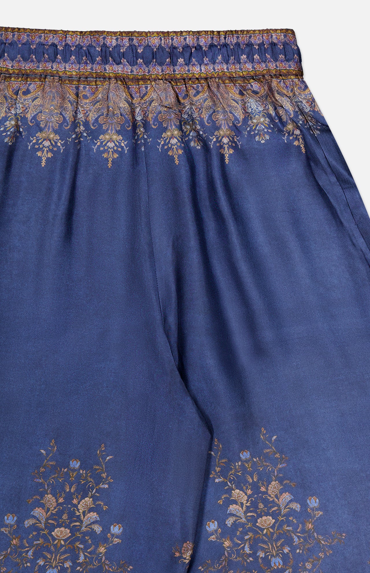 Introducing the ZIMMERMANN Valiant Paisley Print Track Pant—a high-rise, pull-on pant crafted from smooth, slightly glossy fabric for ultimate comfort and elegance. These blue silk pants showcase intricate gold and bronze paisley patterns along the waistband and hem, finished with a detailed ornate border at the top for an elevated touch.