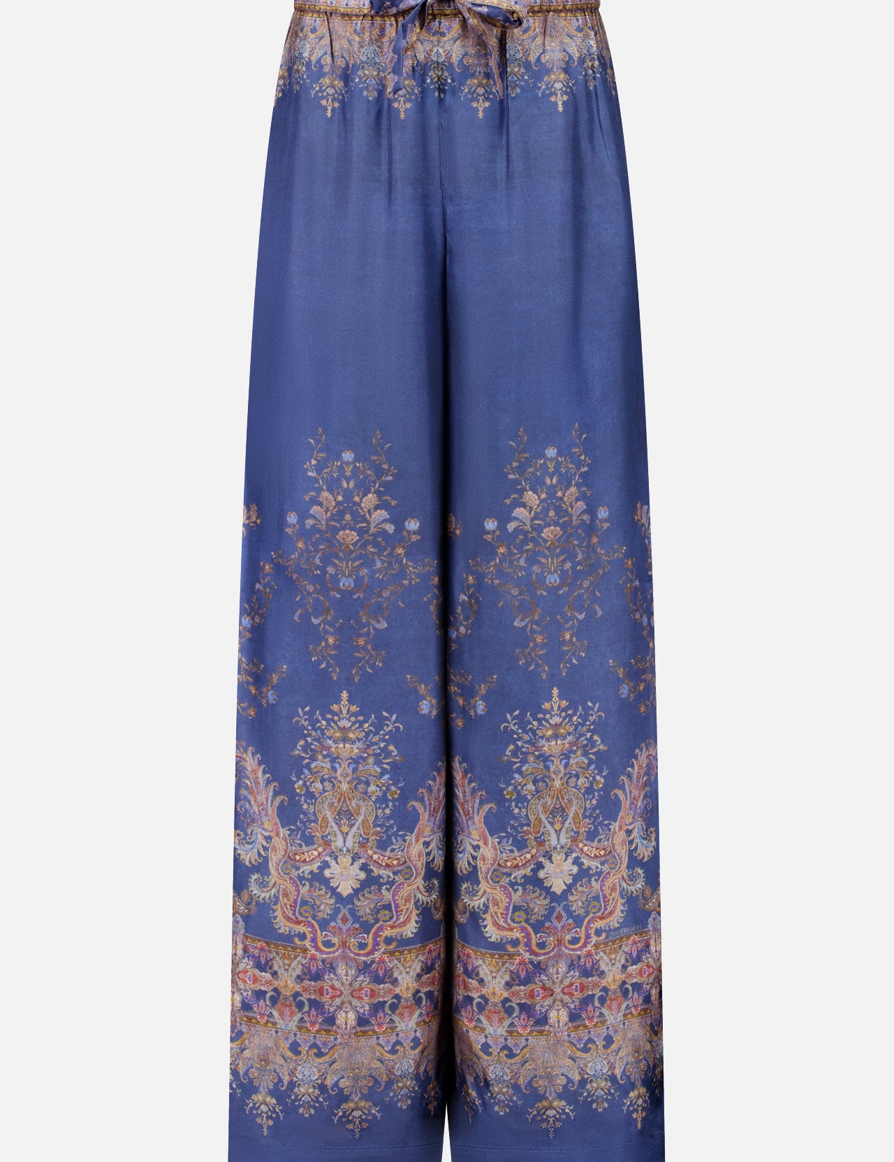 The Valiant Paisley Print Track Pant by ZIMMERMANN features a wide-leg silhouette in silky blue fabric, adorned with an ornate gold and pink paisley floral pattern. These high-rise pull-on pants include an elastic waistband with a drawstring tie, and showcase intricate, symmetrical detailing at both the hem and waist.