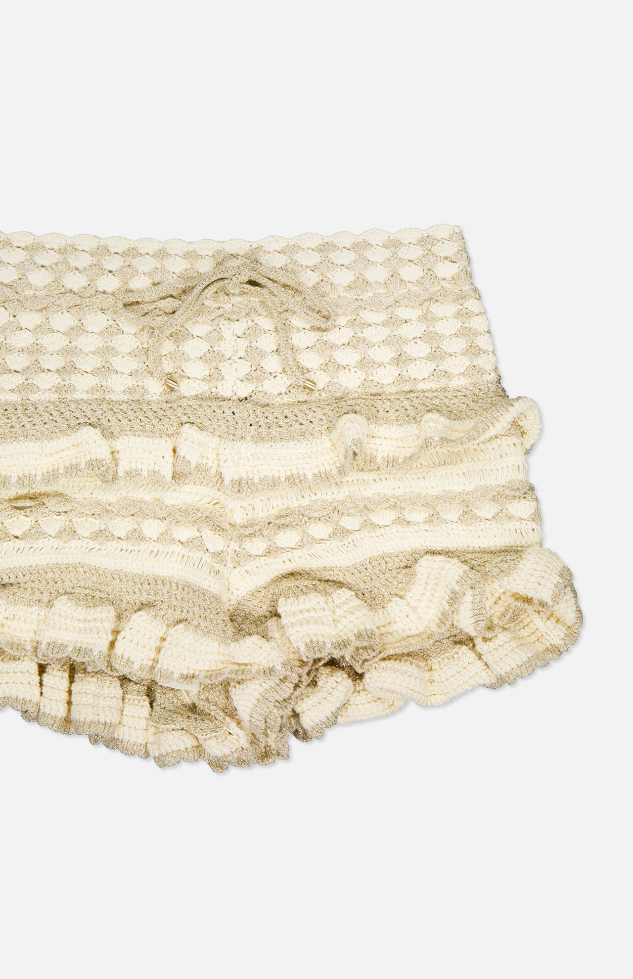 A close-up of the Wanderlust Crochet Short by ZIMMERMANN shows its cream color, hand-knitted texture, and ruffled edges, highlighting delicate craftsmanship against a white background.