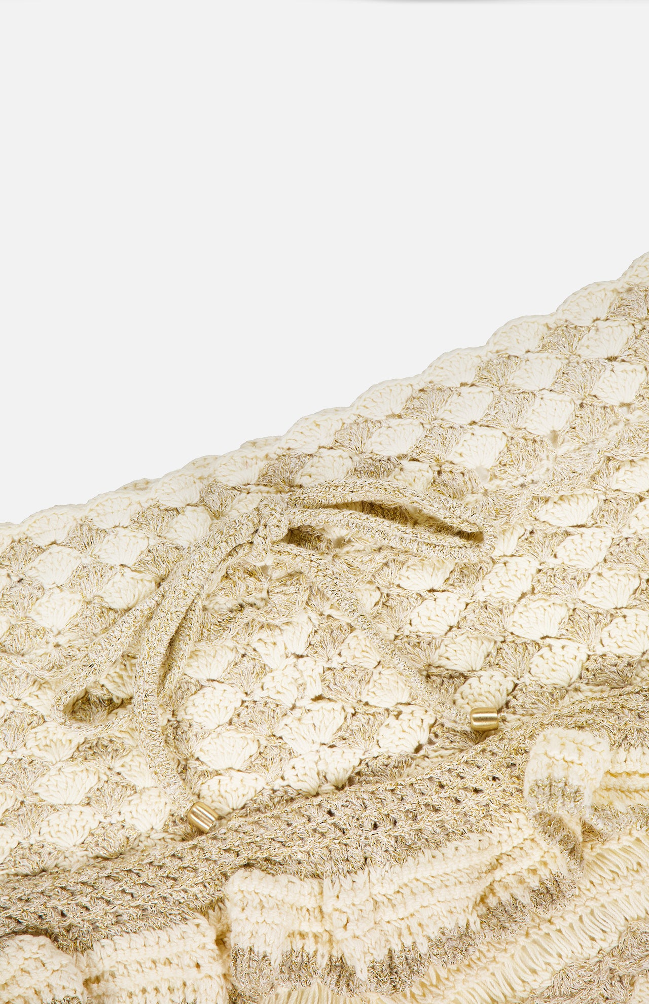 Close-up of ZIMMERMANN’s Wanderlust Crochet Short in cream and gold, featuring a textured scallop pattern and a matching drawstring with gold-tipped ends—perfect for adding elegant flair to your summer look.