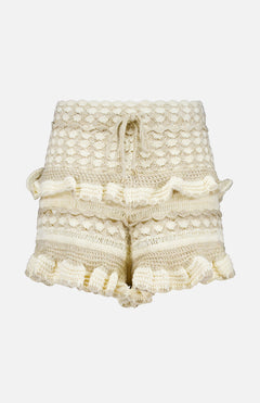 The ZIMMERMANN Wanderlust Crochet Short features a cream hue, high waist, textured crochet pattern, ruffled hems and sides, plus a drawstring waist—perfect summer shorts shown on a plain white background.