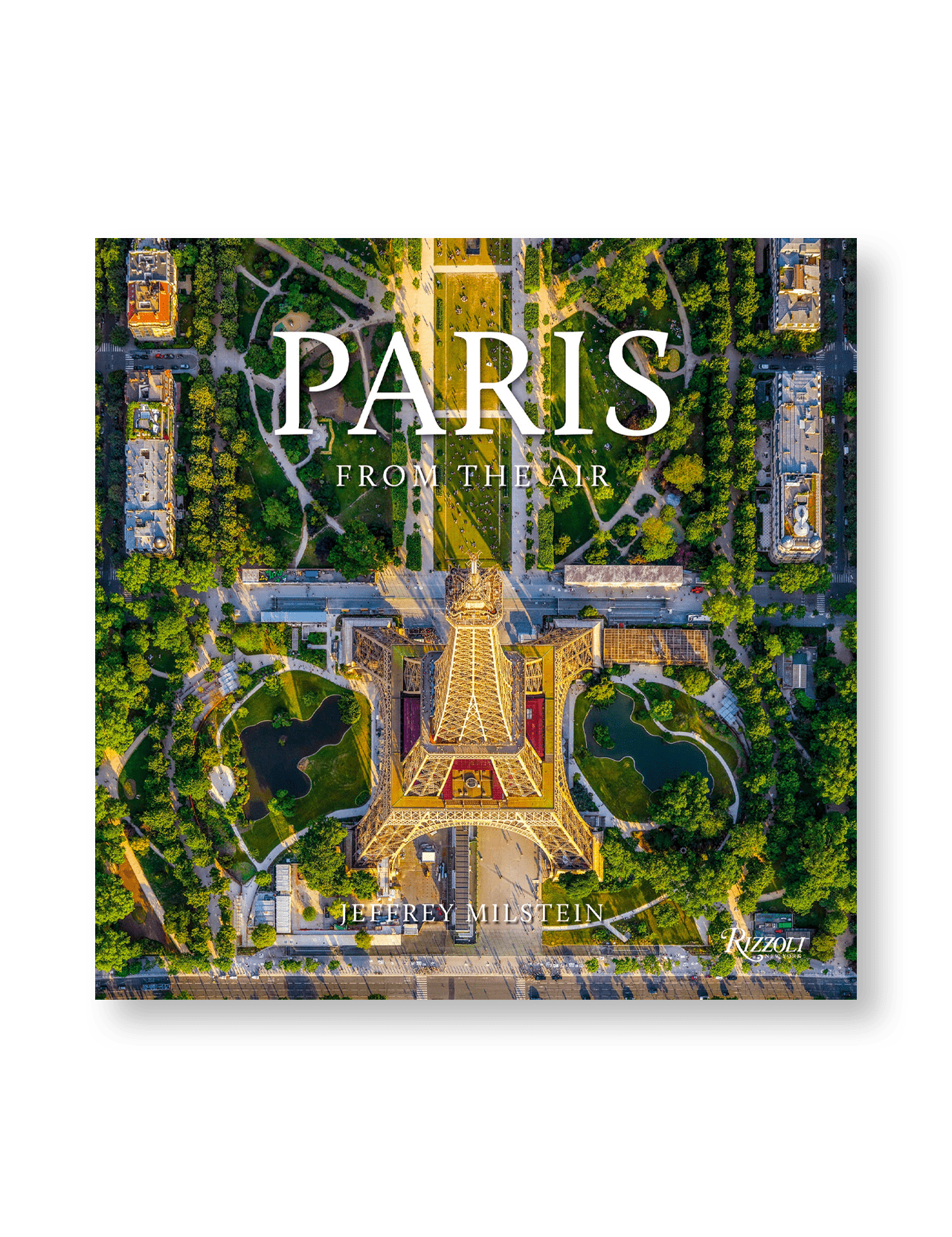 An aerial photo of the Eiffel Tower with lush trees and city streets graces the cover of "Paris: From the Air" by RIZZOLI.