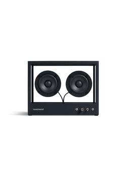 The Small Transparent Speaker by TRANSPARENT features a clear rectangular aluminum frame, two black circular drivers, and control knobs and ports on the lower right front, showcasing its modular design against a plain white background.
